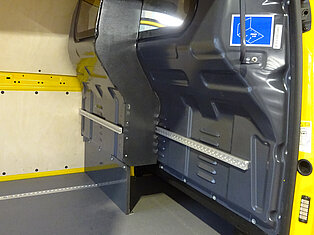 Innenansicht eines gelben Vans mit Metallschienen.