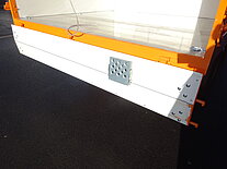 Nahaufnahme der orange-weißen LKW-Heckklappe.