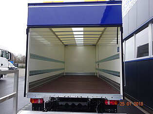 Innenansicht eines leeren LKW-Laderaums mit offener Tür.
