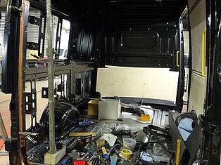 Innenraum eines Vans im Umbau mit Werkzeugen und Materialien.