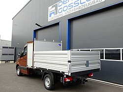 Brauner LKW vor einer Fahrzeugwerkstatt geparkt.