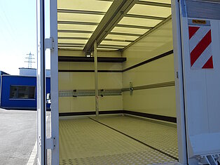 Leerer offener Laderaum eines LKWs mit Metallboden.