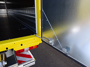 Offener gelber LKW-Laderaum mit Metalltür.