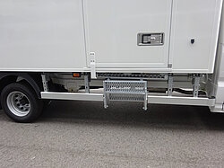 LKW-Seite mit Metalltrittstufe und Tür.