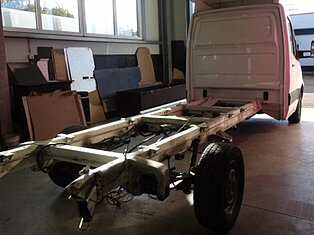 Ein Transporter-Chassis ohne Aufbau in einer Werkstatt.