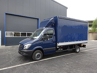 Blauer Lieferwagen vor einem Lagerhaus geparkt.