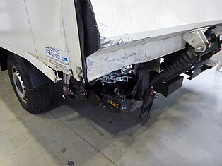 Rückansicht eines Lkw mit sichtbaren Schäden.