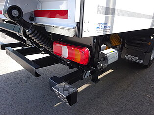 Nahaufnahme des LKW-Hecks mit roten Lichtern und Branding.