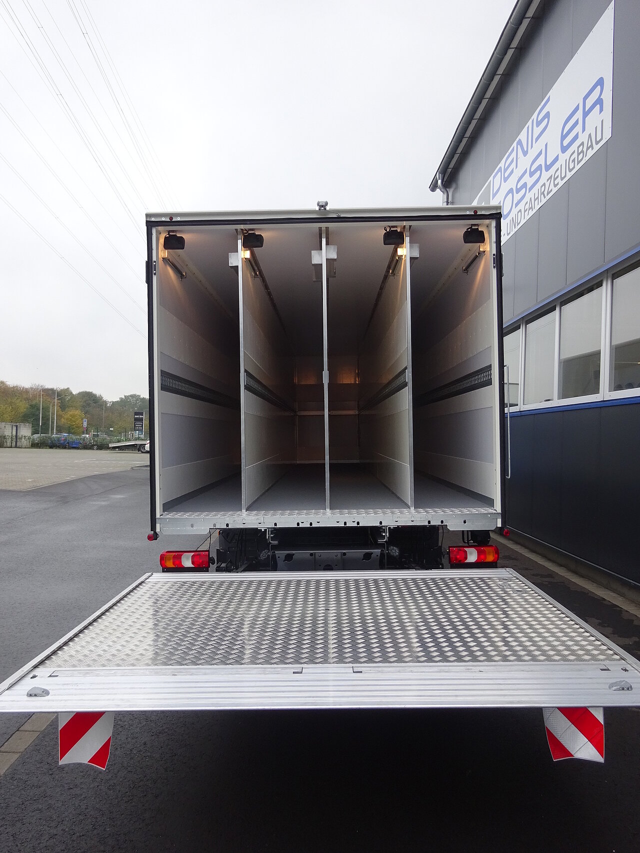 Offener LKW-Laderaum mit Trennwänden und Rampe.