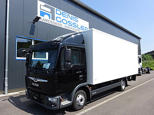 Schwarzer MAN-LKW vor einem Gebäude mit Denis Gossler Schild