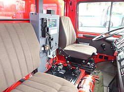 Innenraum eines Feuerwehrautos mit Sitzen und Ausrüstung.