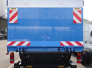 Rückseite eines blauen Lastwagens mit Warnmarkierungen