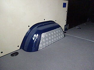 Innenansicht eines Vans mit einem Radkasten und Metallverkleidung.