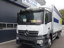 Weißer LKW vor einem Industriegebäude geparkt.