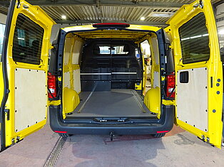 Innenansicht eines offenen gelben Vans mit leerem Laderaum.