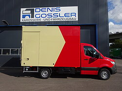 Roter und gelber Lieferwagen vor einem Gebäude geparkt.