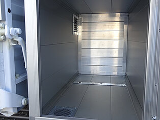 Innenansicht eines leeren Metallfachs an einem Fahrzeug.