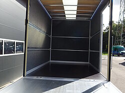 Innenansicht eines leeren LKW-Anhängers mit offener Tür.
