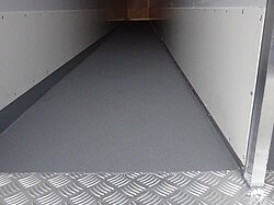 Blick in einen leeren Lkw-Anhänger mit Metallboden.