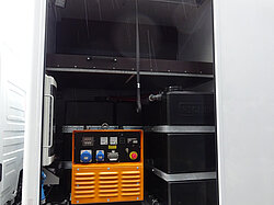Offenes Lkw-Fach mit Generator und Ausrüstung.