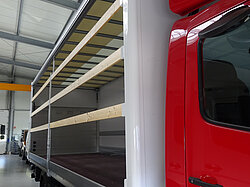 Roter LKW mit offenem Aufbau in einer Halle
