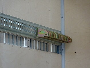 Metallhalterungen an einer Holzwand montiert.