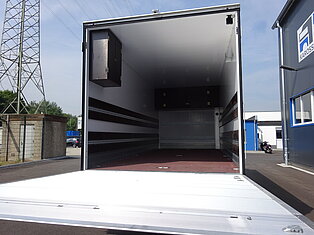 Innenansicht eines leeren LKW-Anhängers auf einem Hof.