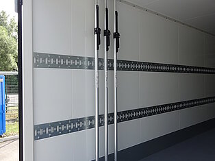 Leerer LKW-Anhänger mit Stangen an der Wand
