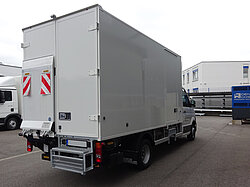 Weißer Lieferwagen im Industriegebiet.