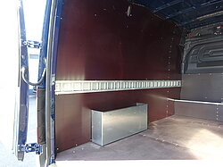 Innenraum eines leeren Vans mit Metallverkleidung und Staubox.