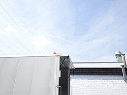 Dach eines Industriegebäudes mit klarem Himmel.