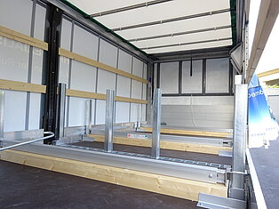 Innenansicht eines leeren LKW-Anhängers mit Metallstützen.