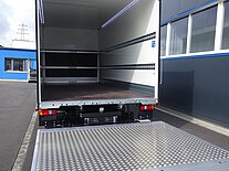 Ein geöffneter LKW mit heruntergelassener Rampe.