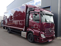 Roter LKW vor einem grauen Gebäude