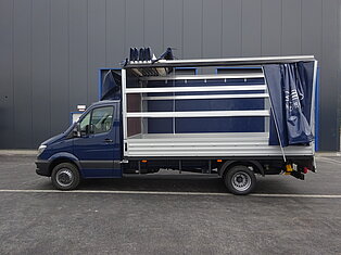 Blauer Lieferwagen mit offener Seitenansicht.