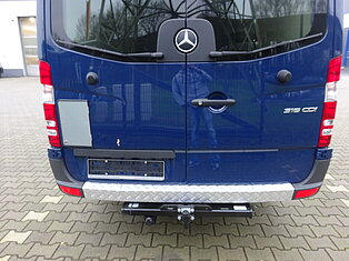 Rückansicht eines blauen Vans mit Anhängerkupplung.
