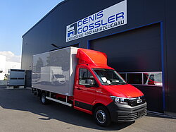 Roter LKW vor Werkstattgebäude.